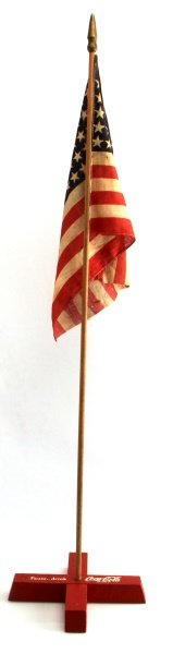 PRE 1956 COCA COLA FLAG STAND ADVERTISEMENT: One Coca Cola brand flag stand ad. Stand itself is painted red, is made of wood, and says "Pause.. drink Coca~Cola". Item has some wear- scuff marks and paint chips, but no major damage. Flag itself f