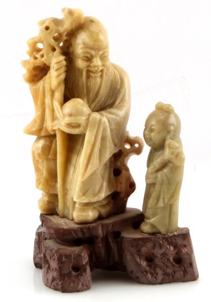 5'' CHINESE SOAPSTONE CARVING OF OLD MAN & CHILD: Chinese soapstone carving of old man with walking stick and a young child to his left, on a carved browm stone base. Item is in very good condition with no signs of damage.