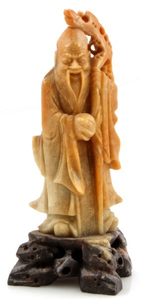 5'' TALL ASIAN SOAPSTONE CARVING OF A MEDICINE MAN: Asian multi-colored soapstone carving of a smiling medicine man with walking stick and coconut in hand. Item measures 5 inches tall with base, and is in good condition with no visible signs of damage.