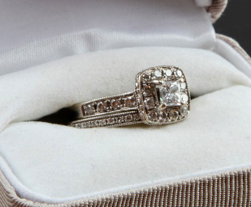 WHITE GOLD BRIDAL SET WITH .4 CARAT CENTER STONE: A 14 karat white gold diamond ring with accompanying 10 karat white gold diamond band. The engagement ring is fitted with a diamond that weighs an estimated .4 carats. This central stone is surrounded