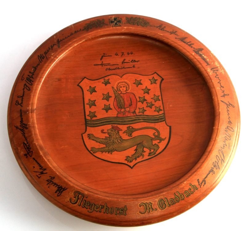 WWII WOODEN PLAQUE FROM CITY TO LUFTWAFFE LT. COL.: Wooden presentation plate/plaque from the city of Mochengladbach to Luftwaffe Lieutenant Colonel Hermann Fundler. The center has the city crest and the date (4.7.44), and text around the edges. Very g