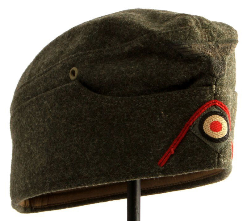 WWII THIRD REICH GERMAN ARTILLERY OVERSEAS CAP: A n overseas or garrison cap with red artillery soutache and diamond shaped cockade patch and eagle patch. The interior is stamped with a marker's mark that identifies its manufacture date (1939) and