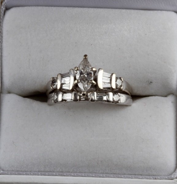 WHITE GOLD ENGAGEMENT SET MARQUISE CUT DIAMOND: Ladies 14 karat white gold engagement set including solitaire with matching band. The solitaire features a .28 ct marquise cut diamond, E/F color, VVS1-2. Eye clean. Also includes melee round and bagu