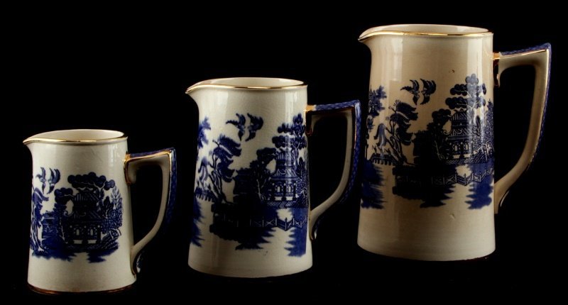 VINTAGE SADLER BLUE WILLOW PITCHERS (3) ENGLAND: Set of 3 English Sadler "Blue Willow" pitchers. Gold trim, marked to bottom. From largest to smallest (7 inches, 5.75 inches, and 4 inches tall. Some crazing. Overall good condition.