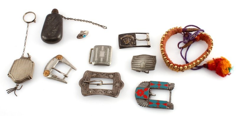 VINTAGE BELT BUCKLE LOT GRAB BAG BOX AND BOTTLE: Vintage and antique grab bag lot including belt buckles, a chatelaine compact, a bottle, an Asian cloth and brass headband or necklace, and a pin. Some tarnishing but all items in overall good conditi