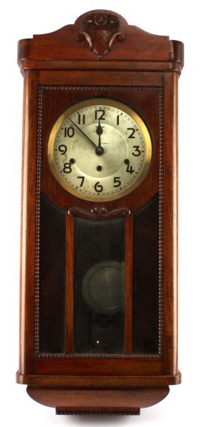 VINTAGE KIENZLE CHIMING WALL CLOCK: A Kienzle German-made chiming wall clock. Measures 31.25 inches tall, 13 inches wide, and 7 inches deep. The moveemnt runs and chimes are functional but the clock may neeed routine maintenance.