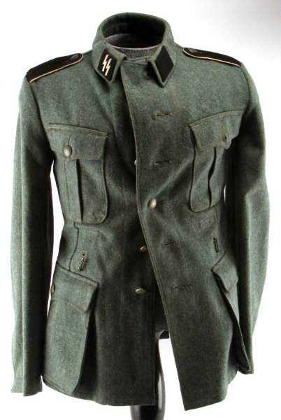 WWII WAFFEN SS 1943 PRIVATE ENLISTED MANS TUNIC: This is a four pocket tunic with an 'SS' runic collar tab and a black rank collar tab machine sewn onto the collar. Has a black wool machine embroidered SS arm eagle on the upper left sleeve. Has a pa