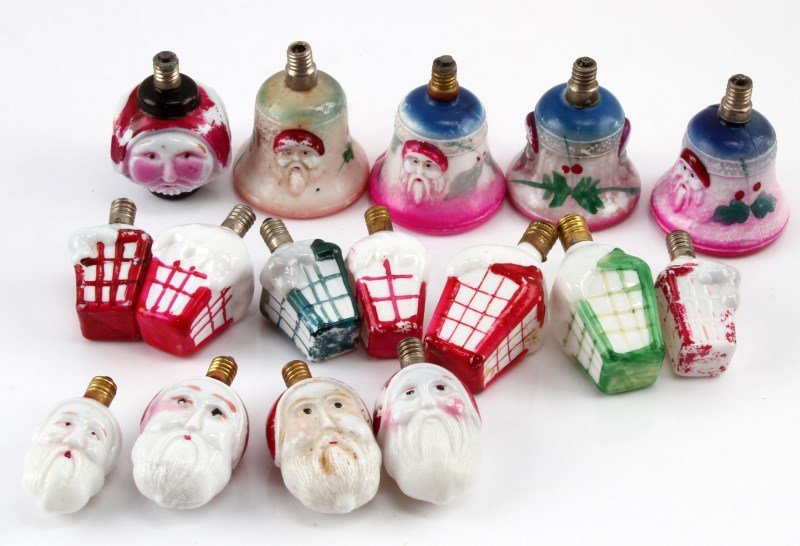 VINTAGE HAND PAINTED MILK GLASS CHRISTMAS LIGHTS: A collection of 16 early 20th century hand painted milk glass Christmas lights. The collection includes 7 snow covered Christmas cottages, 5 double sided Santa faces, and 4 ornate bells with Santa mot