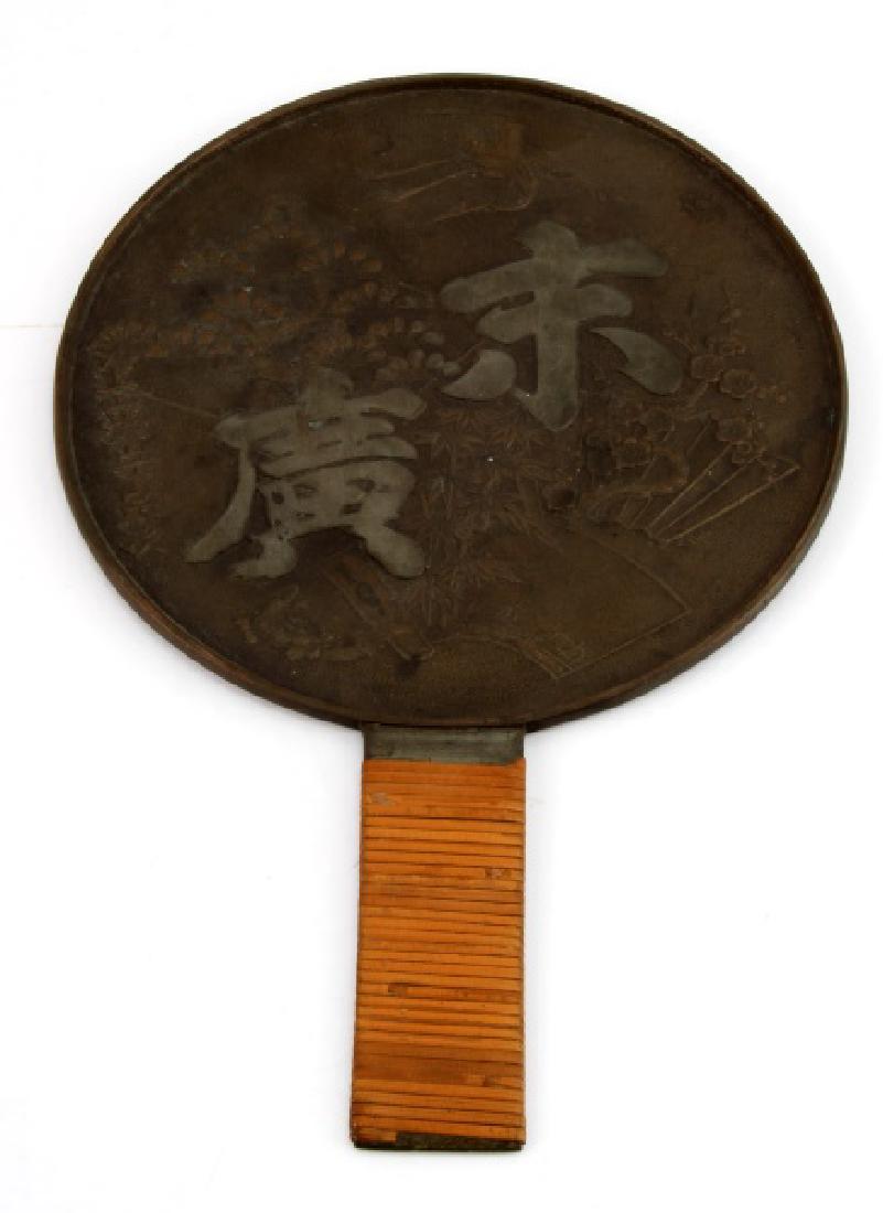 JAPANESE POLISHED BRONZE HAND MIRROR: A Japanese polished bronze hand mirror with bamboo wrapped handle, the back with cranes and calligraphy, 7" diameter. Very good condition. Age related patina has dulled the mirror side.