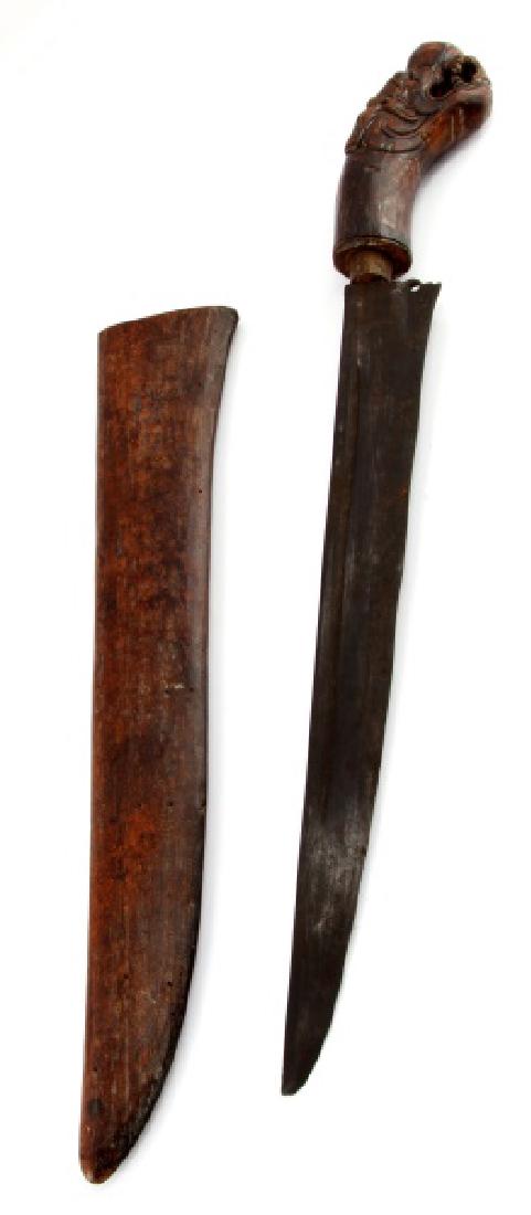 BALINESIAN PISAU PEMUTIC STYLE DAGGER INDONESIA: A pisau pemutik style dagger with carved dragon head hilt likely from the island of Bali. Total length of blade and handle is 16-1/4 inches (41.2 cm) with an 11-1/2 inch (29.2 cm) dark steel blade. Th