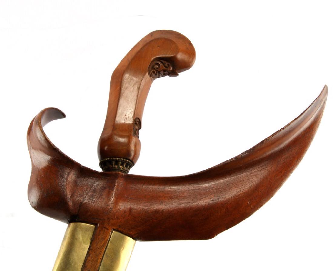 INDONESIAN DAMASCUS STEEL KRIS KERIS DAGGER: The sinuous or serpentine hand-forged Damascus steel blade measures 37-cm (14-1/2 inches). The carved wooden handle measures 11-cm in gross length (4-1/4 inches) and includes carved scrollwork on the 