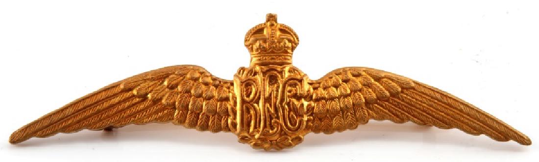 WWI BRITISH ROYAL FLYING CORPS AVIATOR PILOT WING: A stamped brass WWI British Royal Flying Corps (RFC) Aviator Pilot Wing. The badge measures 5-5/8 inches wide by 15/16 inches tall. The reverse has a thinn, 180-degree lie, C-clasp pin back and bears 