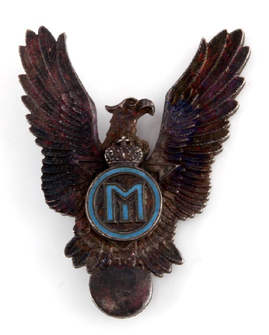 WWII ROMANIAN AIR FORCE PILOT BADGE KING MICHAEL: A rare WWII Romanian Air Force Pilot Badge with the cypher of King Michael in nickel and blue enamel, measuring 2-1/4 inches tall by 1-3/4 inches wide. King Michael's cypher is attached to an earlier 