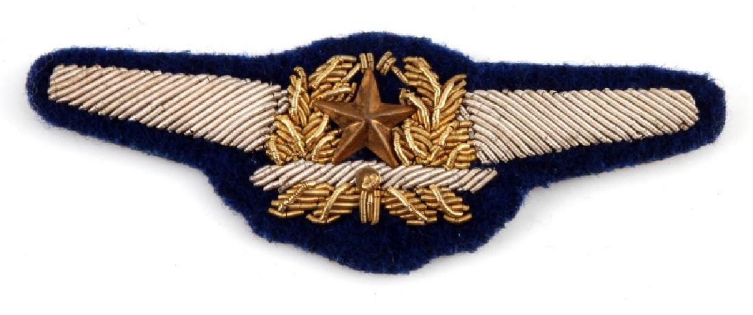 WWII JAPANESE IMPERIAL ARMY AIR FORCE PILOT WING: A WWII Japanese Imperial Army Aire Force Pilot Wing Insignia Patch measuring 3-5/16 inches wide by 1-3/16 inches tall. The silver and gold bullion wire patch is embroidered on a dark blue wool backing