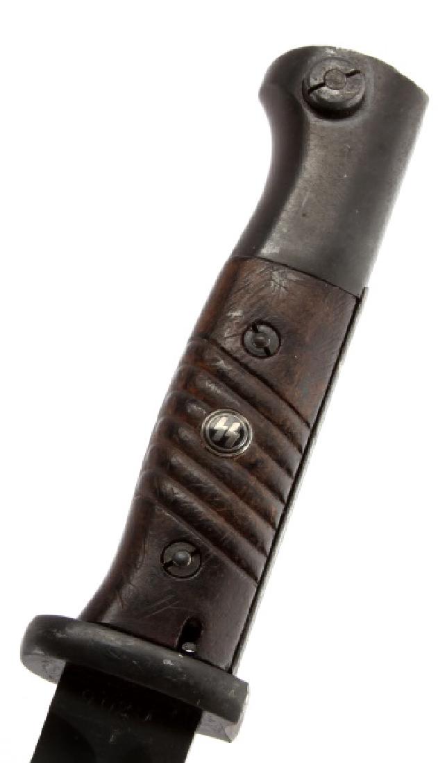 WWII GERMAN SS MAUSER K98 COMBAT RIFLE BAYONET: A WWII German Waffen SS Mauser K-98 Combat Rifle Bayonet and scabbard measuring 16 inches in overall length. The mint condition blued steel blade is marked "F W Holler 9020 f" and measures 9-15/16 inc
