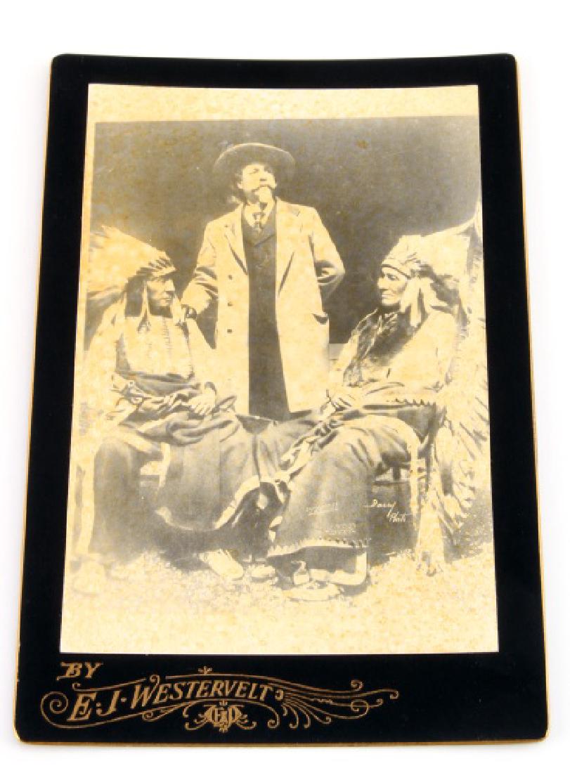 OLD WEST BUFFALO BILL CODY CABINET CARD PHOTOGRAPH: Measures 4 1/4" wide by 6 1/2" tall. The image shows Buffalo Bill standing next to Sioux Indian Chiefs sitting beside him. The photographer's name on the front base reads 'by EJ Westervelt'.