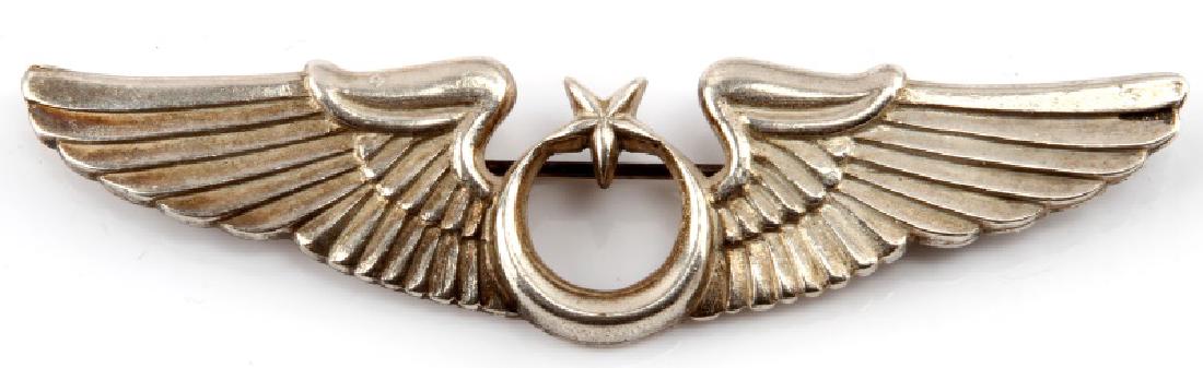 WWII GERMAN TURKISH AXIS AVIATOR PILOT WINGS: A WWII German Luftwaffe Turkish Axis Aviator Pilot Wing Badge measuring 3-1/4 inches wide by 3/4 inches tall. the front shows a central crescent with a star above with a wing on either side. The rever