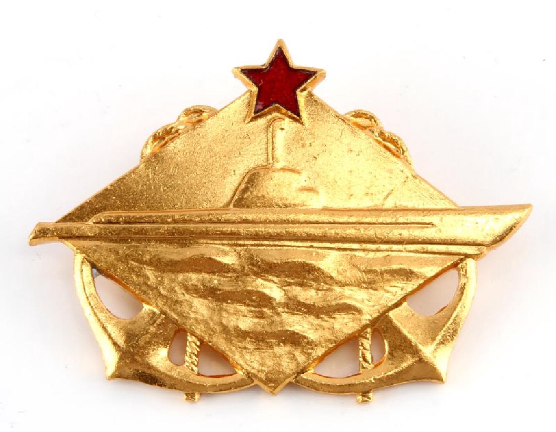 COLD WAR USSR SOVIET SUBMARINE OFFICERS BADGE: A Soviet Russian Cold War USSR Navy Submarine Officer's Breast Badge measuring 2-3/16 inches wide by 1-5/8 inches tall. The front of the brass badge shows a submarine at sea in profile with crossed an