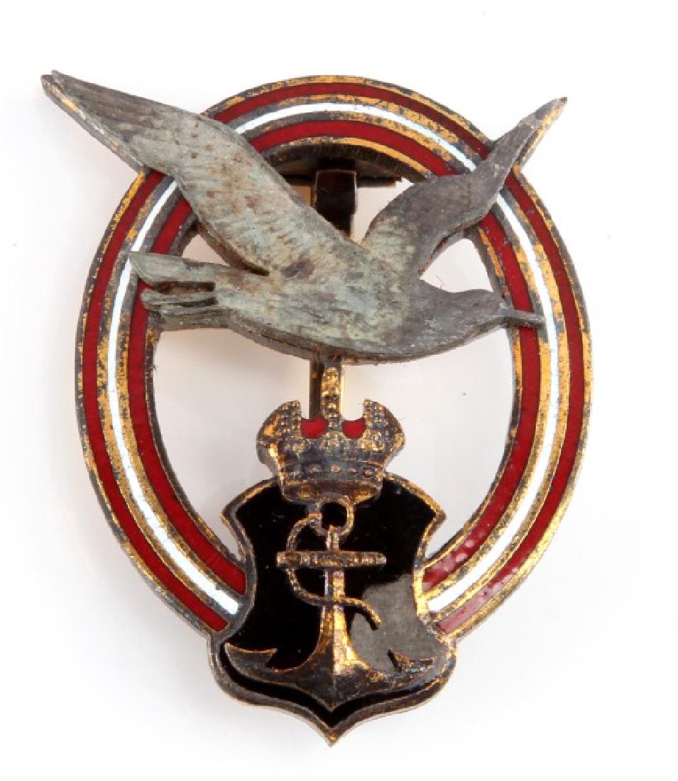 WWI IMPERIAL GERMAN NAVAL AVIATOR PILOT BADGE: A WWI Imperial Austria-Hungary German Naval Aviator Axis Pilot Badge measuring 1-5/16 inches wide by 1-3/4 inches tall. The three piece four domed rivet brass and enamel badge has a wide vertical, 180