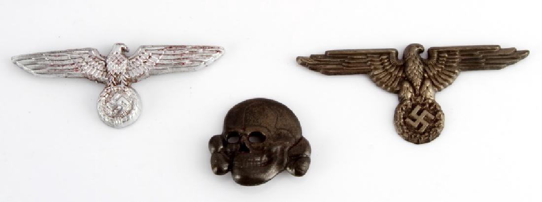 WWII GERMAN 3RD REICH SS VISOR CAP EAGLE & SKULL: A Waffen SS Visor Cap skull and eagle and an Army officer visor cap eagle. The reverse of the stamped nickel skull has the mark "RZM M1/52" The SS Skull and Eagle both have two wide, horizontal mounti