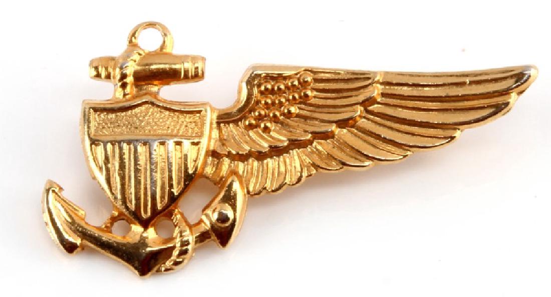 WWII US NAVY BALLOON PILOT WING BADGE: A WWII United States Navy Balloon Pilot Wing badge measuring 1-3/4 inches wide by 1 inches tall. The reverse of the brass badge has a thin, horizontal, 120-degree lie pin back. Unauthenticated, sold a