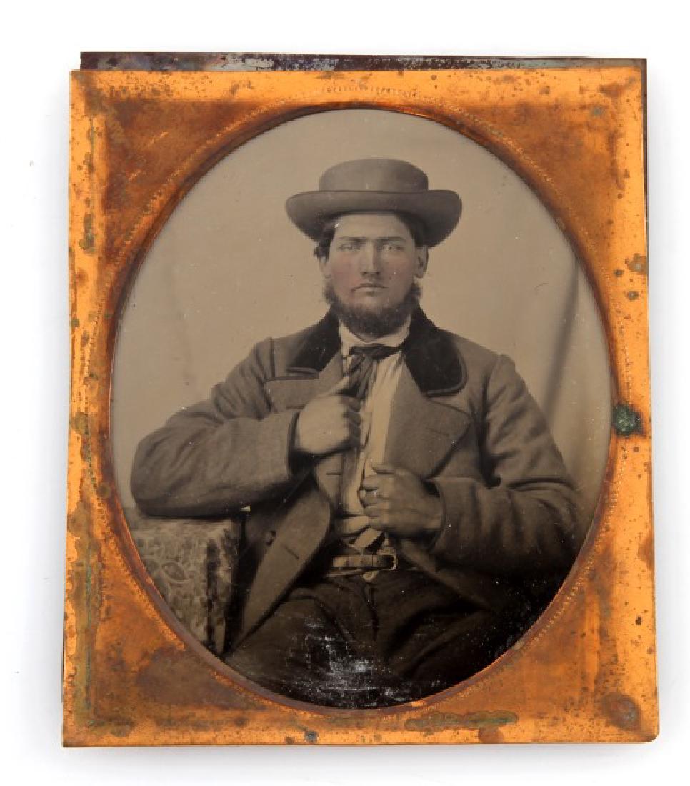 CIVIL WAR ERA RUBY AMBROTYPE 1/6TH PLATE MAN: Antique Civil War era ruby Ambrotype depicting a young man. Ruby Ambrotypes were created on colored glass. The photograph has a copper frame. A 1/6th plate measures 2.75 by 3.25 inches. The edges have