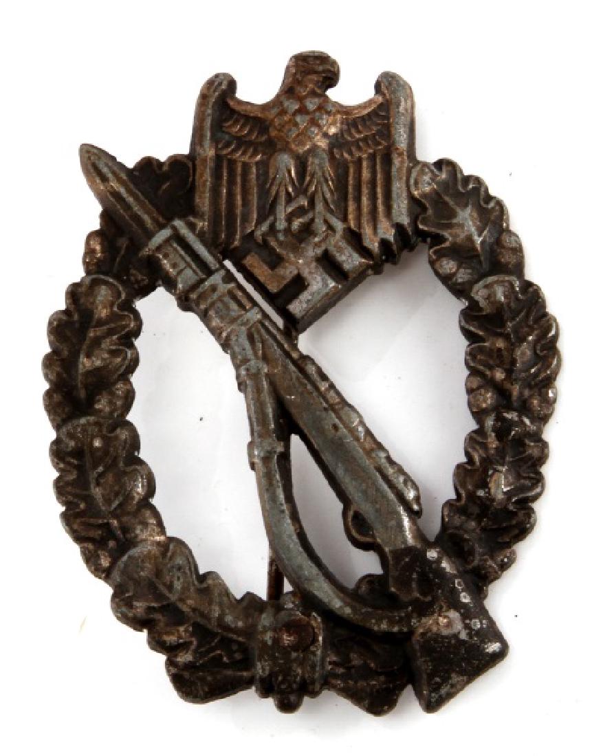 GERMAN WII INFANTRY ASSAULT BADGE: German WWII Infantry Assault badge in silver with fixed bayonet n an oak leaf wreath and eagle/swastika at the top. Reverse marked L/51