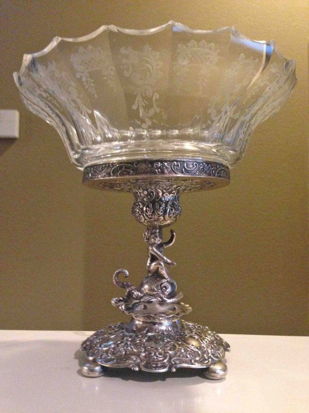 German 800 Silver and Etched Crystal Centerpiece: The crystal etched and mounted on a figural stand depicting a putti riding a dolphin, popular subject of the period. The silver is well cast and fully marked for its silver content, there is some mino