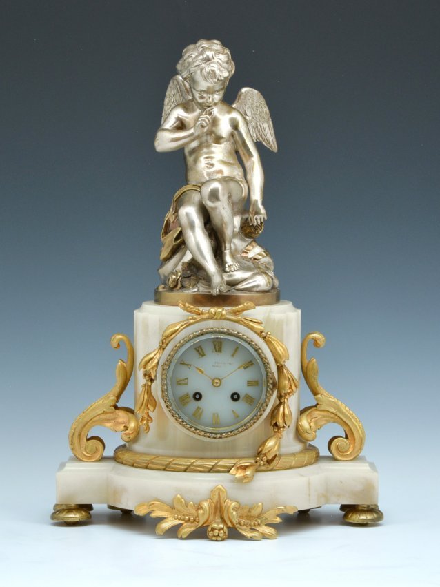 French Silver Gold Gilt Bronze Marble Cupid Clock 19thc: Fine French Silver & Gold Gilt Bronze Cupid Clock with "Opaline glass face" on fancy marble base with columns and ormolu mounts. 19.5"h x 12.5"w x 14.5"d.