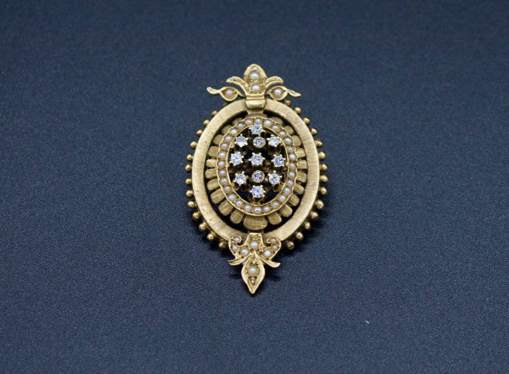 Diamond and gold Victorian brooch, can be pendant: Diamond and gold Victorian brooch that can be worn as a pendant. Brooch is set at center with eleven old mine cut diamonds of approx. 0.1 carats each. Brooch has an elaborately set seed pearl bezel an