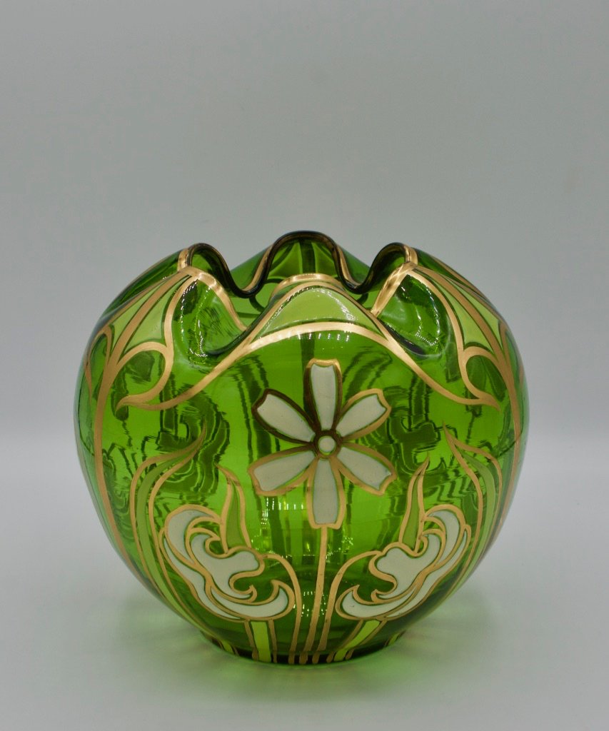 Gilt and enamel decorated green art glass rose bowl: Art Nouveau gilt and enamel decorated green art glass rose bowl with stylized iris and daisy image. Circa 1910, as is, one side of rose bowl has a scratch that runs through the flower design on one si