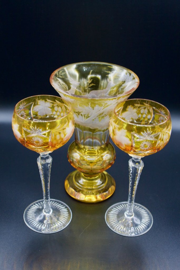 2 Bohemian amber cut to clear hock wine glasses/vase: Pair of Bohemian amber cut to clear hock wine glasses and a vase, circa 1925. Glassware has a meandering grape vine cut glass pattern on bowl and six-sided clear stems with notch cut edges. Glasses te