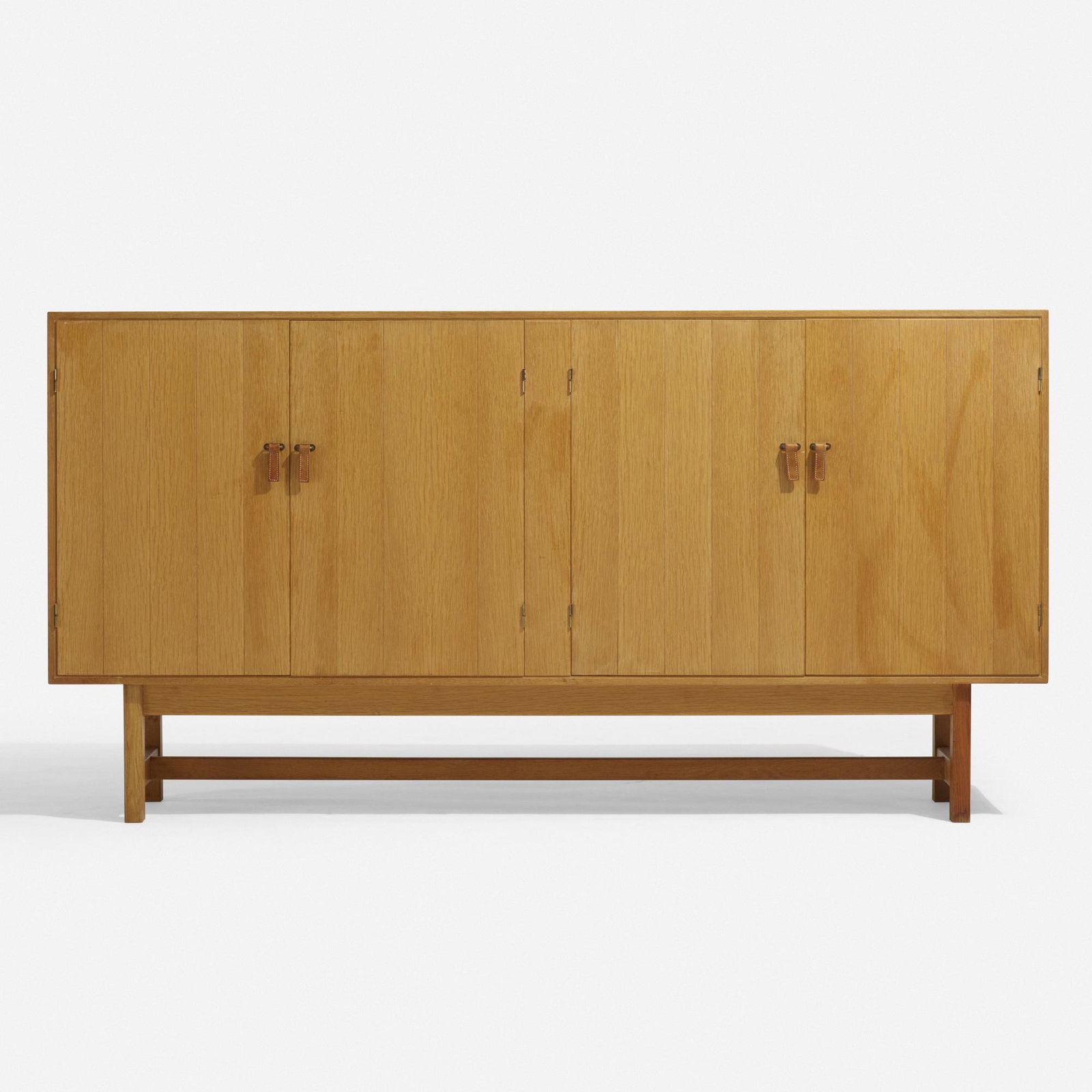 Kurt Ostervig, cabinet: Kurt Ostervig cabinet K.P. Mobler Denmark, c. 1960 oak, leather 84.5 w × 18.5 d × 43.5 h in (215 × 47 × 110 cm) Cabinet features four doors concealing five removable tr