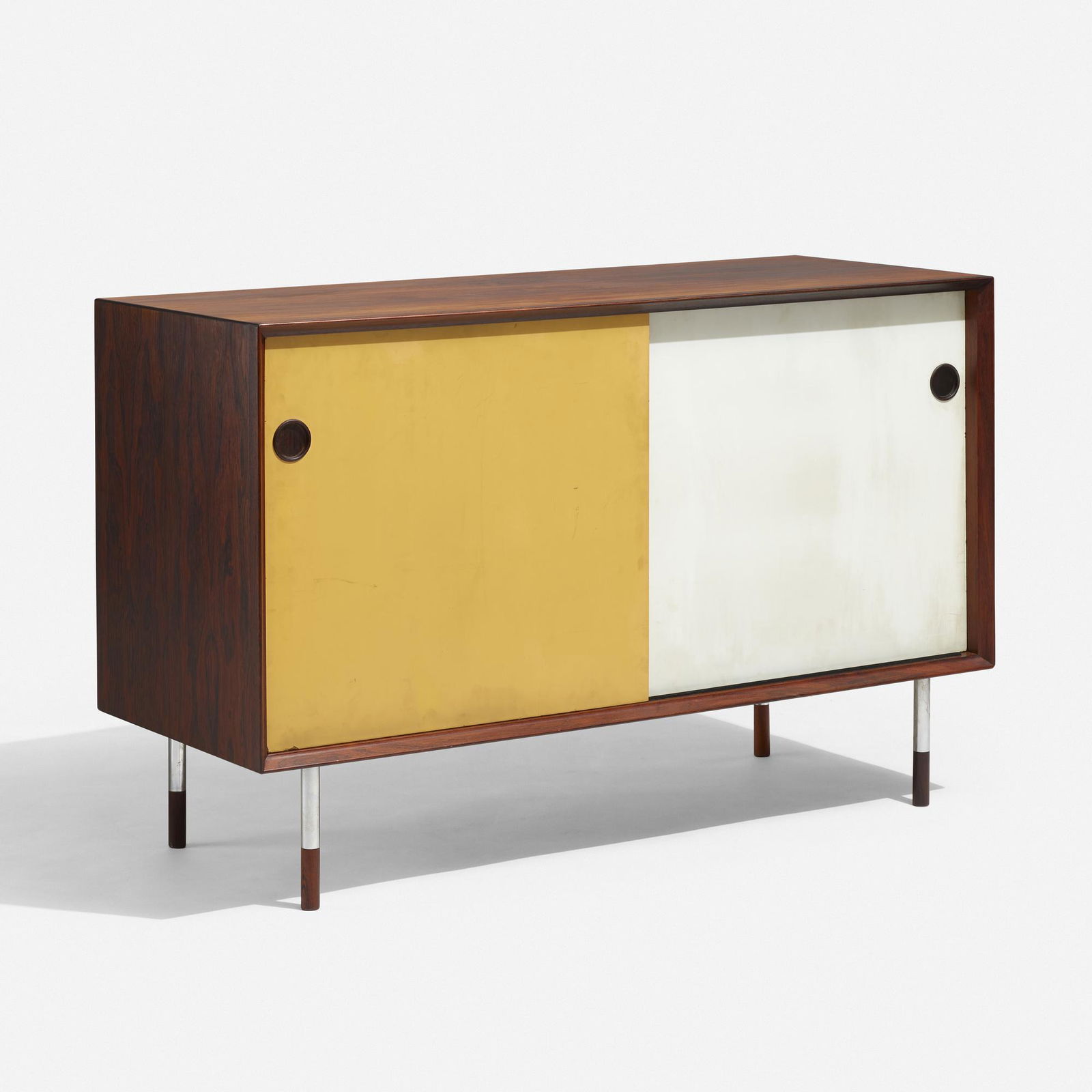 Arne Vodder, cabinet: Arne Vodder cabinet Sibast MoblerDenmark, c. 1960rosewood, lacquered masonite, chrome-plated steel49.5 w × 19.5 d × 31.75 h in (126 × 50 × 81 cm) Cabinet featutes two sliding doors conceali