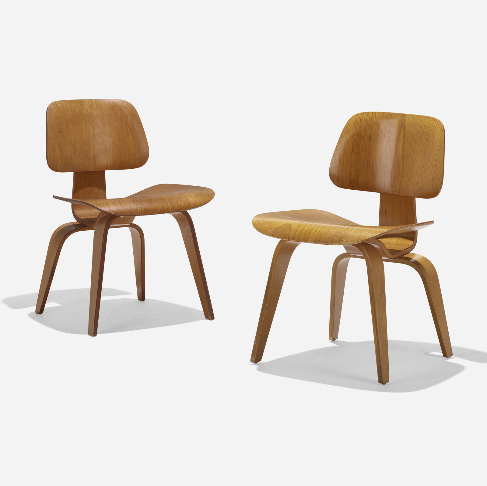 Charles and Ray Eames, DCWs, pair: Charles and Ray Eames DCWs, pair Herman Miller USA, 1945 / c. 1955 walnut plywood, rubber 19.25 w × 20 d × 29 h in (49 × 51 × 74 cm) Literature: The