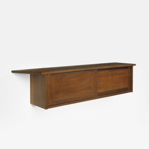 George Nakashima Hanging Wall Case: George Nakashima Hanging Wall Case USA, c. 1960 American black walnut 58.25 w x 14 d x 14.25 h inches Cabinet features an overhanging, joined top above two sliding doors concealing two compartments wi