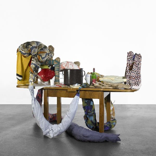 John Bock 1 = 2 + Kleinod: John Bock 1 = 2 + Kleinod Germany, 1999 wooden table, fabric, teapot, two VHS cassette tapes, one DVD, bulls-eye, wire, book, ceramic pitcher, one bag of peas, wine bottle; video: 32 minutes, 33 secon