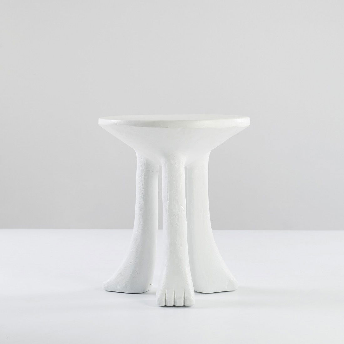 John Dickinson African table: John Dickinson African table USA, c. 1975 painted plaster 22 dia x 26 h inches Sold with a copy of Architectural Digest illustrating this example. Literature: Architectural Digest, Nov./Dec. 1973, pg.