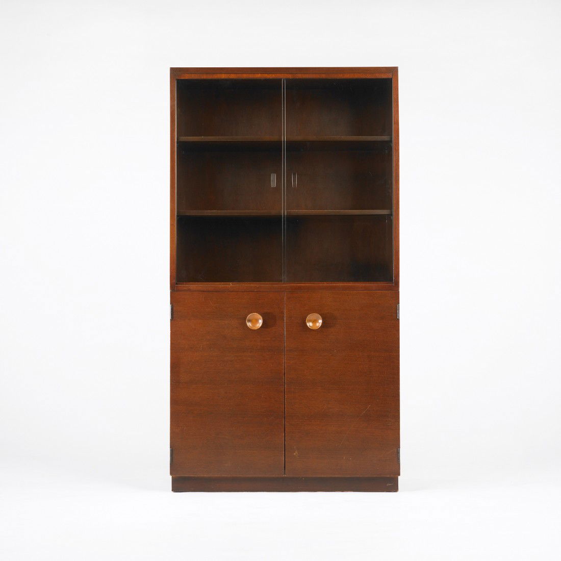 Gilbert Rohde cabinet: Gilbert Rohde cabinet Herman Miller USA, c. 1940 mahogany, stained beech, glass 33 w x 16 d x 31.5 h inches Cabinet features two sliding glass doors concealing two adjustable shelves and two doors con