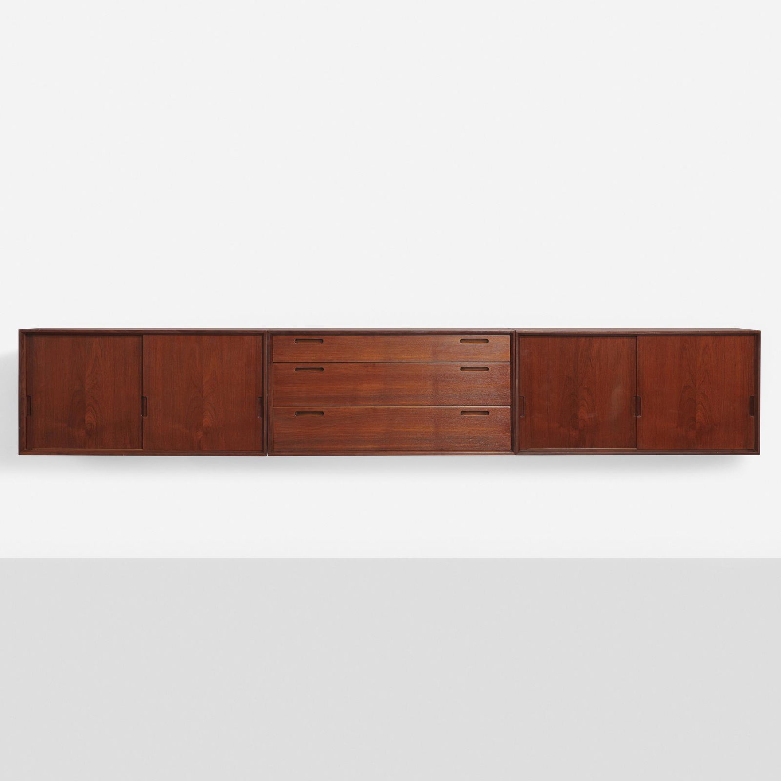 Ib Kofod-Larsen, Wall-mounted cabinets: Ib Kofod-Larsen Wall-mounted cabinets, set of three Brande MobelfabrikDenmark, c. 1960teak 14.75 h x 31.25 w x 15.75 d in (37 x 79 x 40 cm) Two cabinets feature two sliding doors conceal