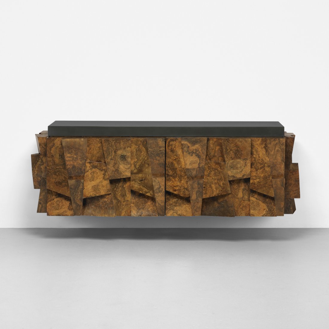 Paul Evans wall-mounted faceted cabinet: Paul Evans wall-mounted faceted cabinet Paul Evans Studio for Directional USA, c. 1975 walnut burl, lacquered fiberglass 81.25 w x 24.5 d x 27 h inches Cabinet features two doors concealing two adjust