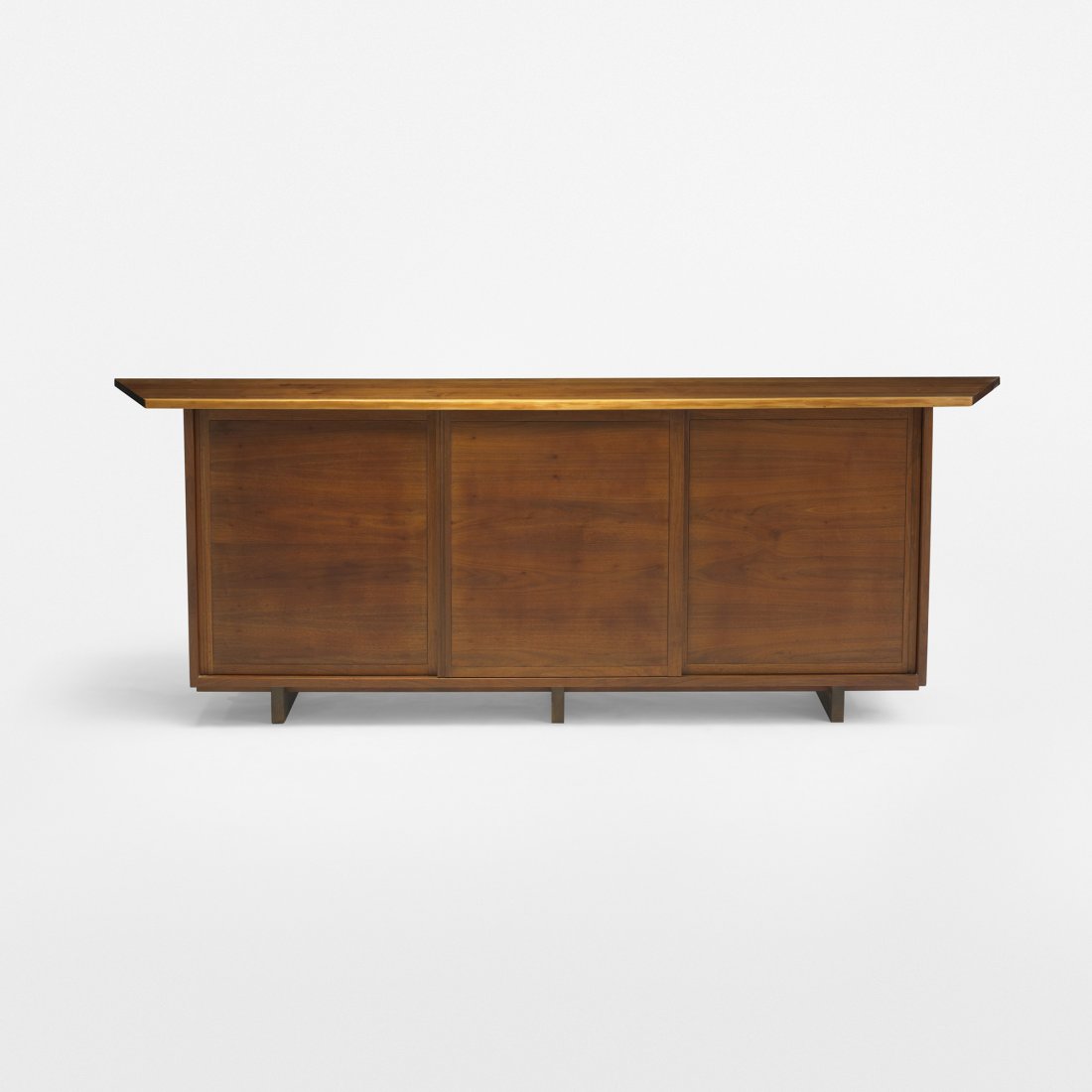 George Nakashima Sliding Door Cabinet: George Nakashima Sliding Door Cabinet USA, c. 1960 American black walnut 108 w x 21 d x 38.25 h inches Cabinet features a joined top with sap-grain detail and a free edge; three sliding doors conceal 