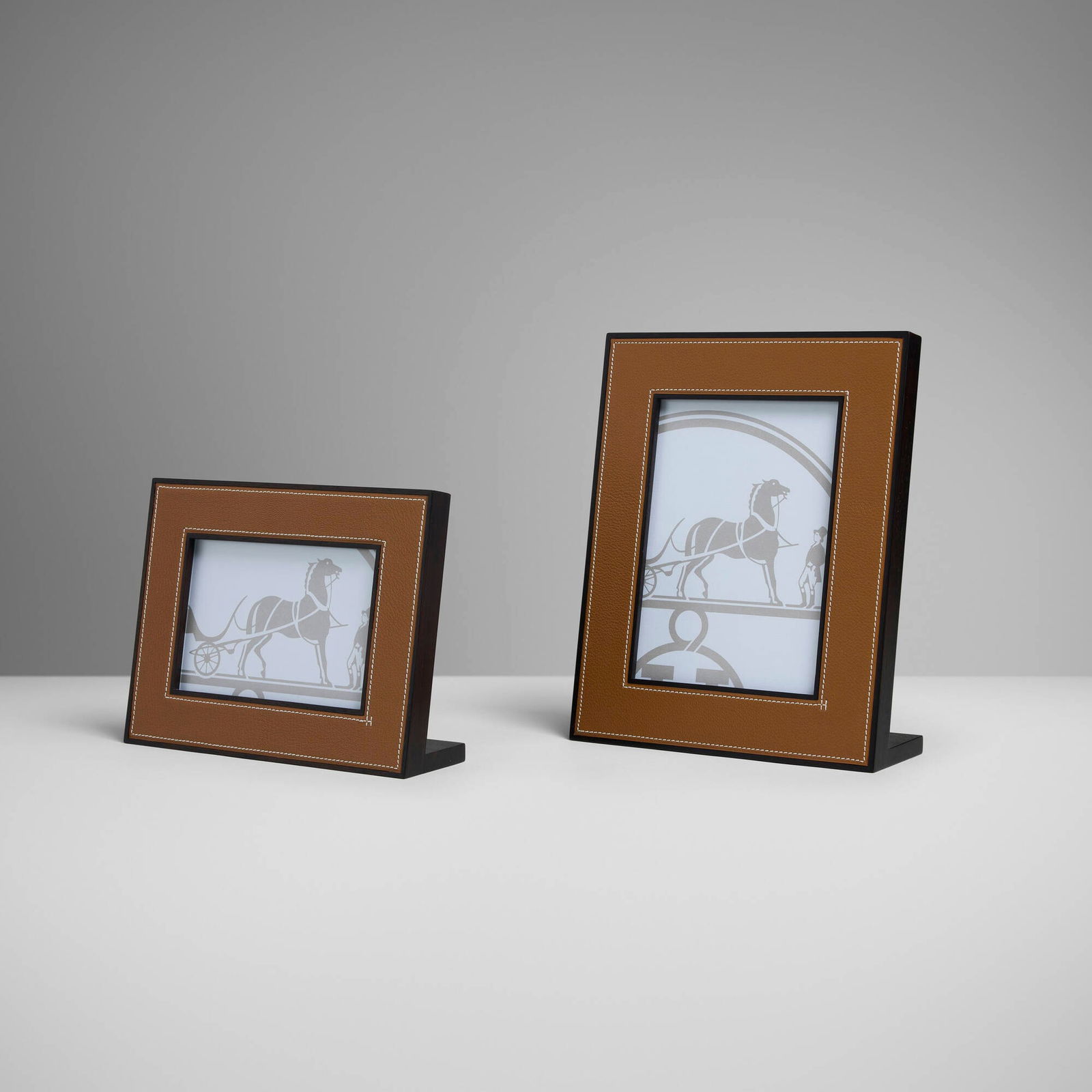 Hermes, Pleiade picture frames, set of two: Hermes Pleiade picture frames, set of two France, c. 2010leather, mahogany, glass 10 h x 8.125 w x 2.75 d in (25 x 21 x 7 cm) 6.5 h x 8.5 w x 2.375 d in (17 x 22 x 6 cm) Impressed manufactu