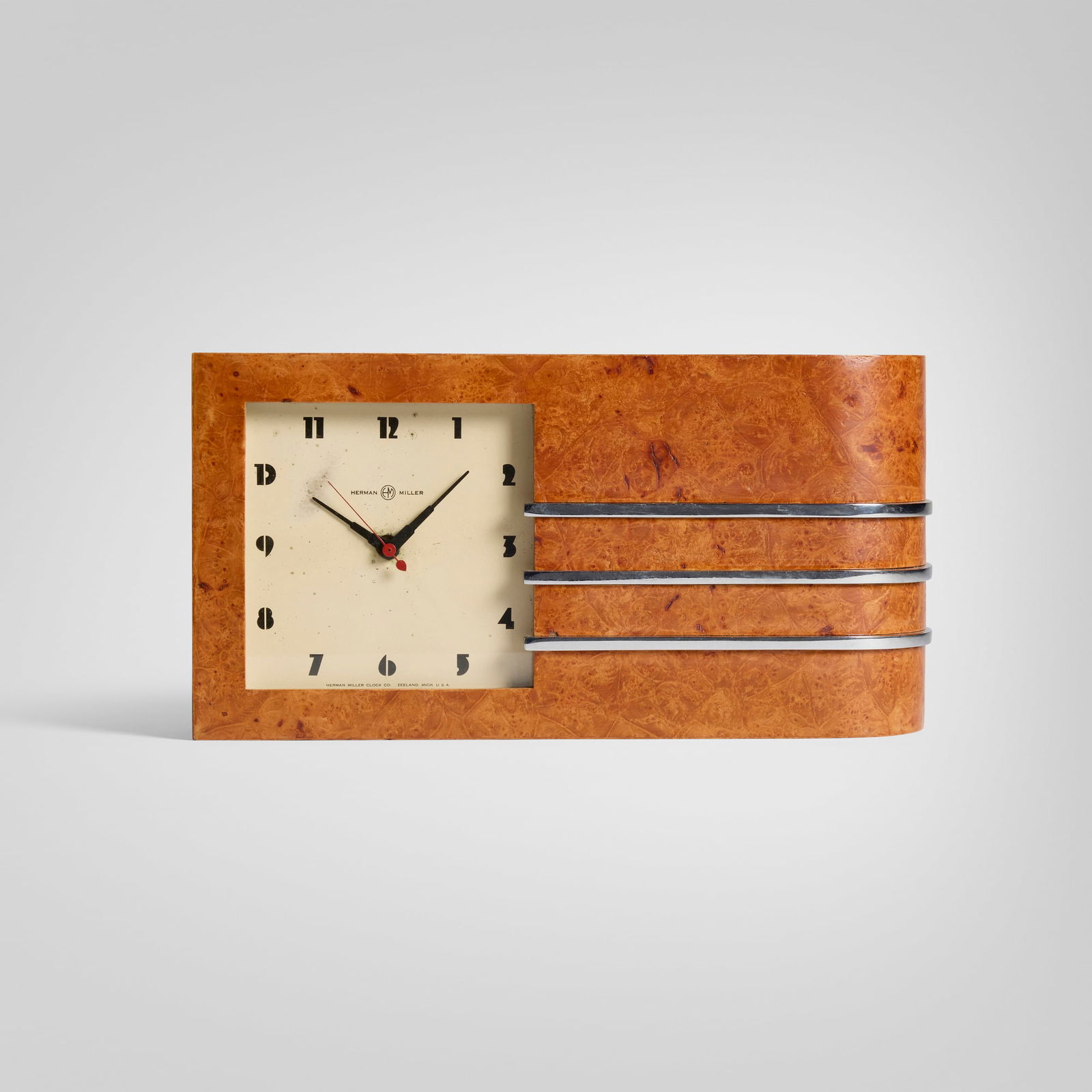 Gilbert Rohde, World's Fair table clock, model 4082: Gilbert Rohde World's Fair table clock, model 4082 Herman Miller Clock CompanyUSA, c. 1933Maidou burl, chrome-plated steel, enameled aluminum, glass 7 h x 13.25 w x 2.75 d in (18 x 34 x 7 cm)