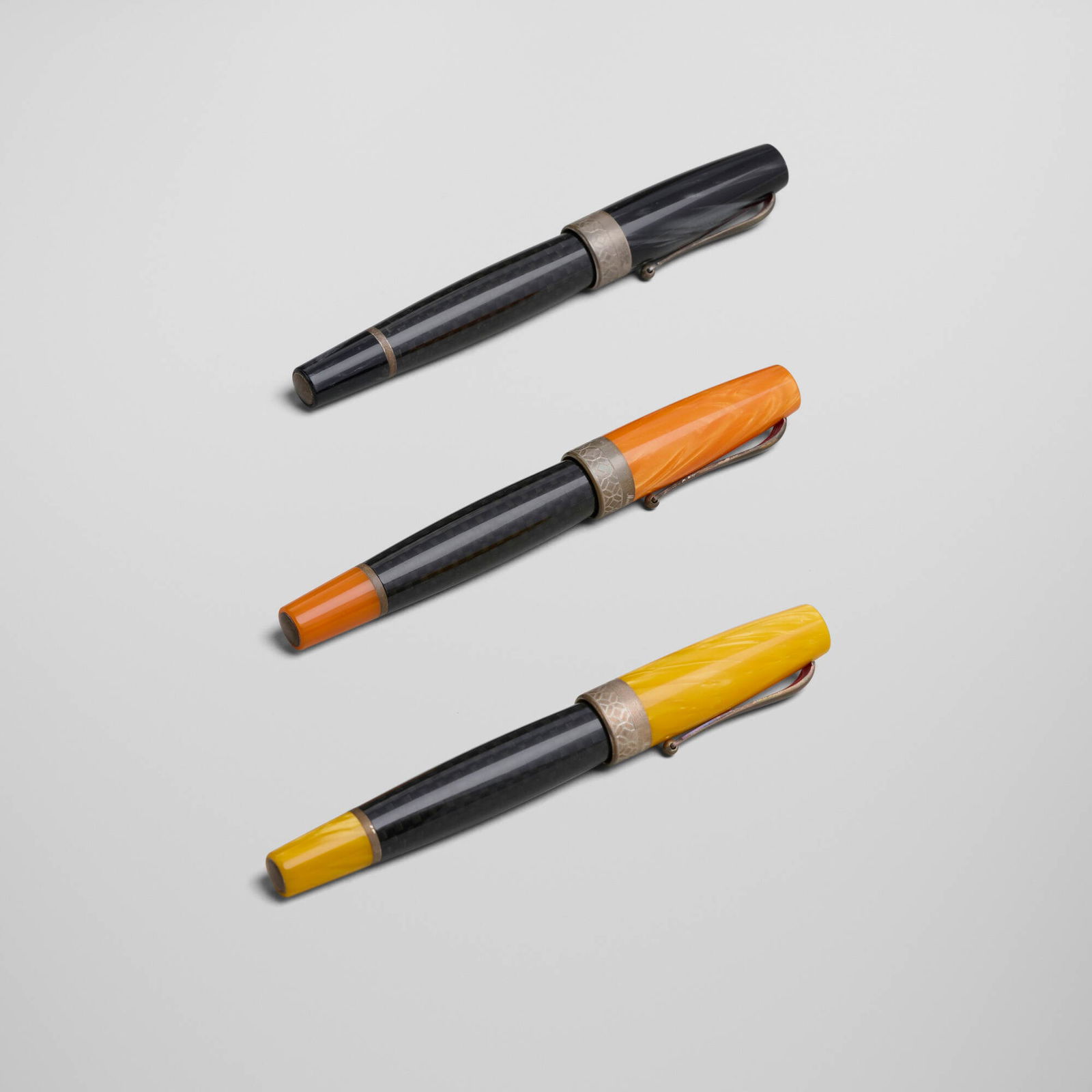 Montegrappa, Miya Carbon ball pens, set of three: Montegrappa Miya Carbon ball pens, set of three Italy, c. 2015 celluloid, carbon fiber, sterling silver 5.25 h x 0.75 w x 0.5 d in (13 x 2 x 1 cm) Impressed manufacturers mark to each