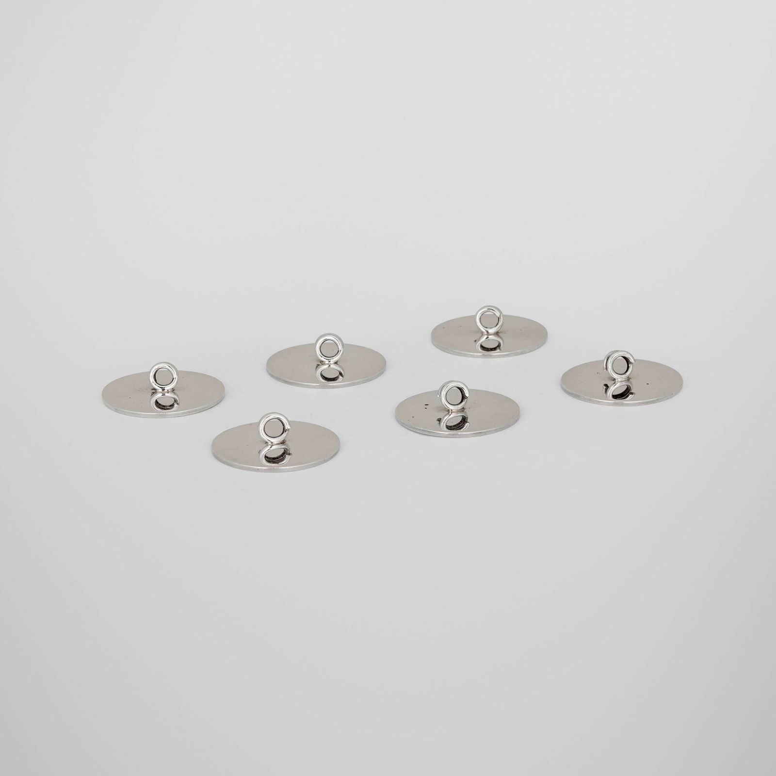 Cartier, Place card holders, set of six: Cartier Place card holders, set of six France, c. 1960sterling silver 0.5 h x 1.25 dia in (1 x 3 cm) Impressed manufacturer's mark to underside of each example 'Cartier Sterling 18'. 3.208 ozt