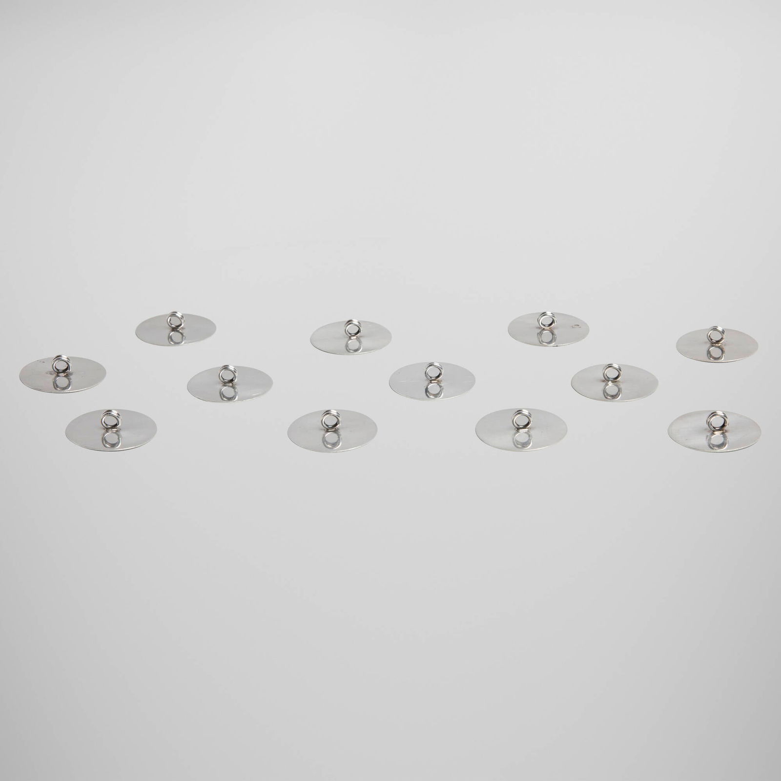 Lutz, Place card holders, set of twelve: Lutz Place card holders, set of twelve USA, first half of the 20th centurysterling silver 0.375 h x 1.375 dia in (1 x 3 cm) Impressed manufacturer's mark to each example 'Lutz Sterling'. 2.424