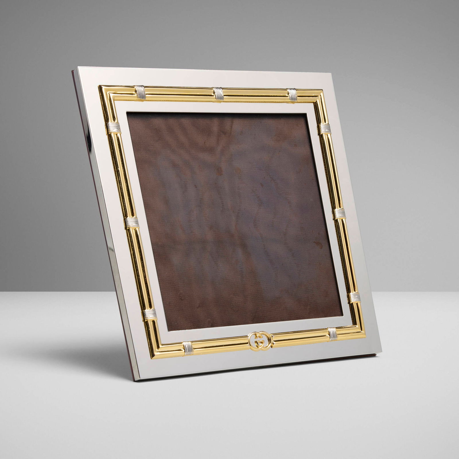 Gucci, Picture frame: Gucci Picture frame Italy, c. 1985 silver-plated and gold-plated metal, glass, exotic wood 7.75 h x 7.75 w x 4 d in (20 x 20 x 10 cm) Impressed manufacturer's mark to underside 'Gucci Made in