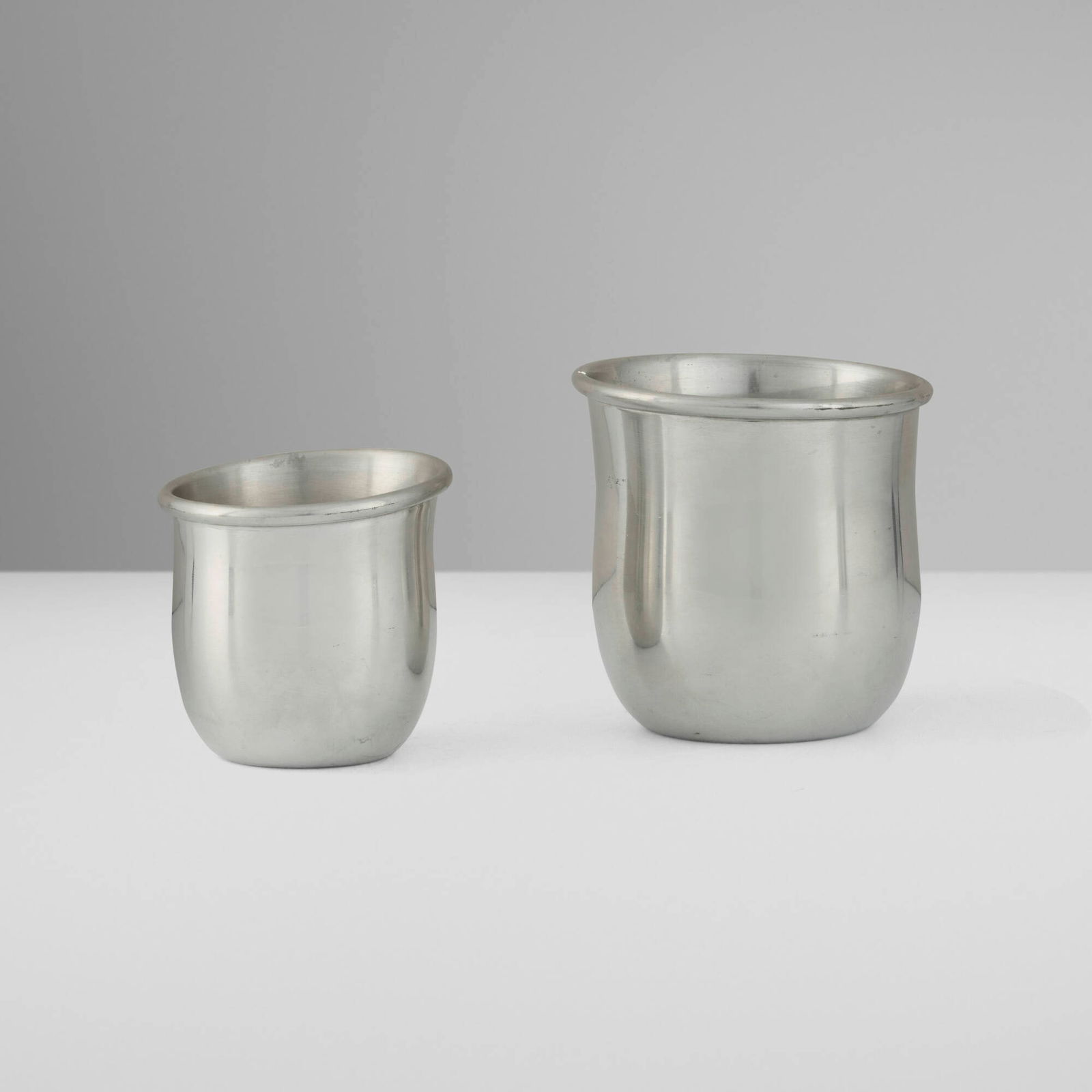 Hermes, Saddle vases, set of two: Hermes Saddle vases, set of two France, c. 1970 stainless steel 3.75 h x 3.75 dia in (10 x 10 cm) 3 h x 3 dia in (8 x 8 cm) Impressed manufacturer's mark to each example 'Hermes Etain'. This