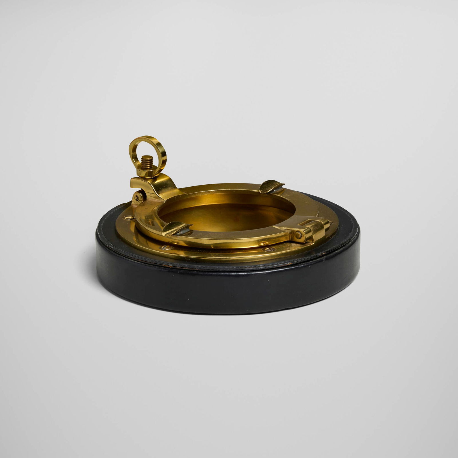 Gucci, Porthole ashtray: Gucci Porthole ashtray Italy, c. 1950brass, leather, wood 3.5 h x 7.75 dia in (9 x 20 cm) Impressed manufacturer's mark to underside 'Gucci Made in Italy'. This work will s